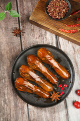 Marinated Duck Tongue in Red Flavored Glaze with Spices on Wooden Table