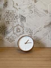 Minimalist round clock against patterned hexagon tiles