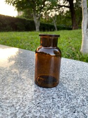 Amber glass bottle on stone table outdoors