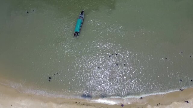 Aerial view of turquoise tropical waters with boats and huts on Pelawan beach, Karimun Regency, Riau Islands, Indonesia
