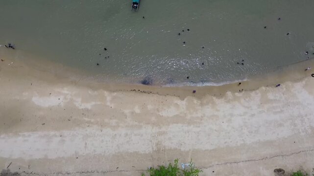 Aerial view of turquoise tropical waters with boats and huts on Pelawan beach, Karimun Regency, Riau Islands, Indonesia
