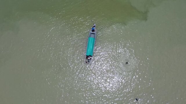 Aerial view of turquoise tropical waters with boats and huts on Pelawan beach, Karimun Regency, Riau Islands, Indonesia