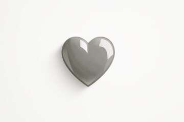 Fototapeta premium metal heart shaped sculpture resting on white surface with glossy gray tone, reflecting light from above, cloud dancer color of 2026, concept of home decor, gift shop, art gallery