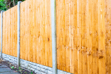 A three quarter view of brand new fence panels in the garden with concrete posts