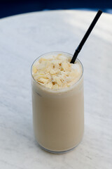 Tall glass of iced latte with almond flakes
