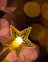 Lumière en forme d'étoile avec fond flou, jaune et rose, vertical