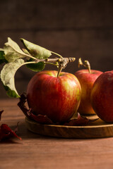 Freshly picked red apples, autumn rustic wooden background, dark, moody style