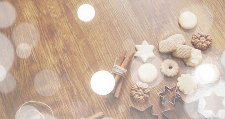 Displaying baked cookies, metal star cutters, cinnamon, powdered sugar on wood table, copy space