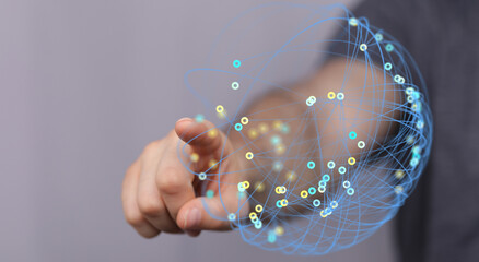 Hand reaching out to touch a network sphere representing global technology, connection, and digital communication.