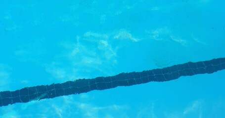 Showing mosaic-tiled lane marker running diagonally across pool, with rippling bright reflections © vectorfusionart