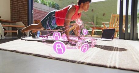 Maintaining man in red top holding plank on mat at home with holographic network, purple dumbbells