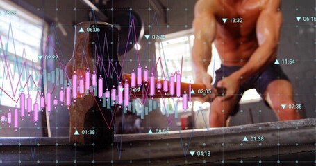 Swinging hammer shirtless man in shorts striking tire at gym, charts, copy space