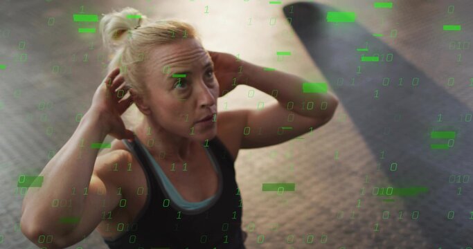 Doing crunch, fit woman with hands-behind-head on rubber floor with green overlay in athletic wear - Powered by Adobe