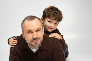 Father and son share a joyful moment in cozy sweaters during family bonding time