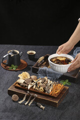 Traditional Asian Mushroom Soup with Dried Fungi and Medicinal Ingredients on Dark Kitchen Counter