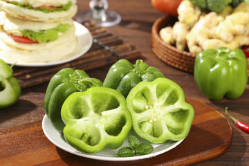 Fresh Green Bell Peppers Sliced and Whole on Kitchen Counter - Healthy Organic Vegetables for Cooking