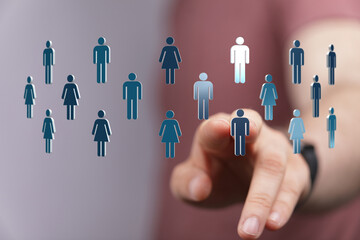 Hand pointing towards digital human icons, representing social connection, communication and virtual teamwork. Concept for global network, busin