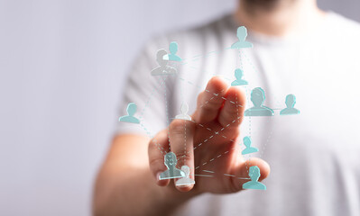 Fototapeta premium Person's finger interacting with a holographic network of people, visualizing teamwork, communication, and collaboration. Focus on human interac