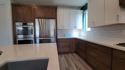Stylish And Roomy Kitchen Featuring Sleek Appliances And Decorative Illumination Fixtures