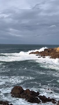 1080p footage of Atlantic Ocean waves crashing against rocky shore in La Coru&ntilde;a, Spain. Windy afternoon with white foam and strong sea movement.