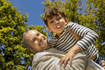 Joyful moments between father and son under a bright blue sky in a lush green park