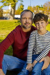 Fototapeta premium Father and son share a joyful moment in a sunny park, capturing love and laughter together
