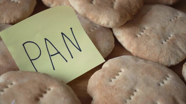 A close-up shot of a stack of fluffy pita bread with a handwritten note that says PAN on it. this image is an appetizing delight that celebrates the simplicity and comfort of food.