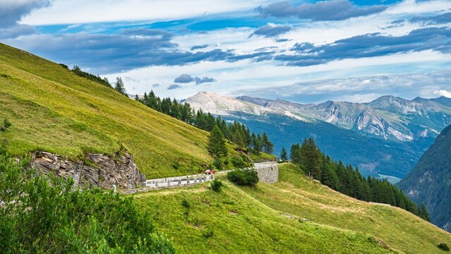 A scenic alpine pass road in Austria Alps, Kaprun offers breathtaking views of mountains and lush green hills, perfect for travel agencies and landscape photographers. - Powered by Adobe