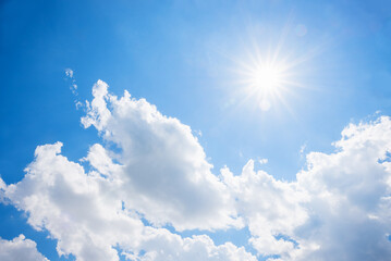 Brilliant sunshine in a blue sky above airy white fair-weather clouds
