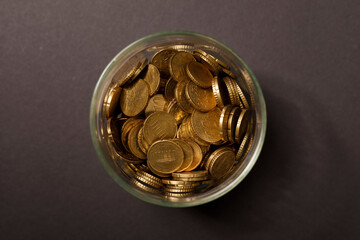 Close-up shot of gold coins in a glass jar, a visual metaphor for savings, investment, wealth and financial gr