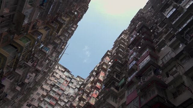 Hong Kong&rsquo;s Building Canyon: Rows of windowed facades pinch the sky to a narrow slit; piled AC units and weathered walls knit a tight urban fold in the cramped space.