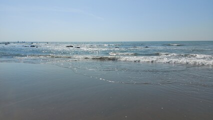 Seascape view of gentle waves and sunlight sparkling on the water.