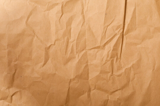 Close up of a crumpled brown Kraft paper texture. Perfect for backgrounds, design elements, and adding a vinta