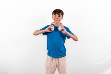young casual dressed fun happy Gen Z influencer white male model teenage boy with wireless headphones for listening to music podcast or social media from digital device plain background studio setting