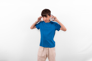 young casual dressed fun happy Gen Z influencer white male model teenage boy with wireless headphones for listening to music podcast or social media from digital device plain background studio setting