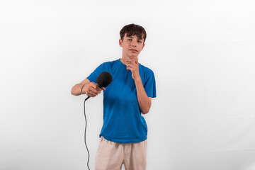 young casual dressed Gen Z entertainer influencer white male host model teenage boy with microphone for singing, presenting and interviewing for social media channel. plain background studio setting