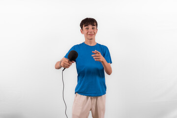 young casual dressed Gen Z entertainer influencer white male host model teenage boy with microphone for singing, presenting and interviewing for social media channel. plain background studio setting