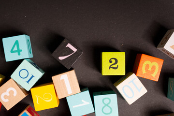 Close-up of vibrant wooden blocks with numbers on a dark surface, perfect for educational content,...
