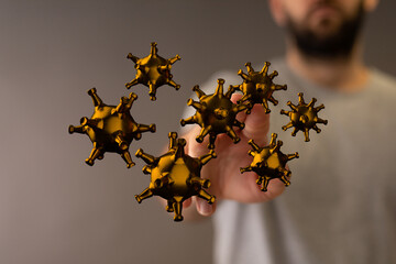 An abstract, artistic rendering of golden virus particles floating in front of a person's hand, representing c
