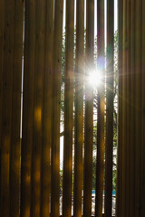 Obraz premium Sunrise shining through wooden bars building terrace on a beautiful morning scene