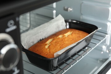 Tasty lemon cake baking in oven, closeup