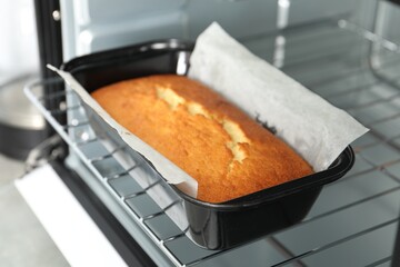 Tasty lemon cake baking in oven, closeup