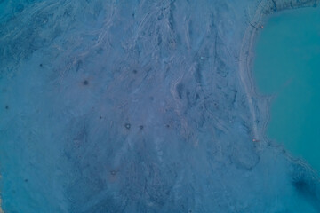 Aerial top down view of smooth blue industrial sludge with crater pockmarks. Toxic waste texture and surreal alien surface background pattern.