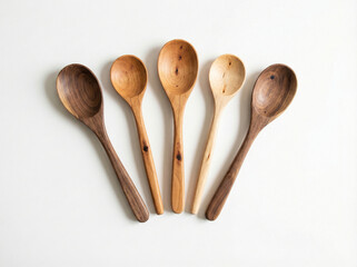 Group of five various natural wood cooking spoons and spatulas arranged in a fan shape isolated on a white background