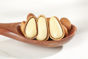 Pine Nuts in Wooden Spoon - Peeled Kernels and Red Shells Natural Food Ingredient