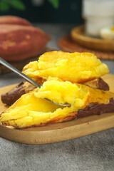 Golden Roasted Sweet Potato with Fluffy Yellow Flesh on Wooden Board
