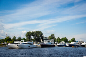 A marina scene with luxury yachts and motorboats. The vessels vary in design for travel brochures, luxury lifestyle magazines, real estate promotions.