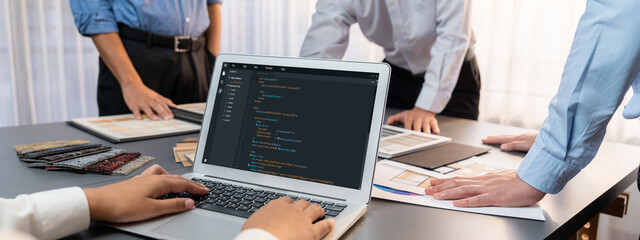 Group of interior architect designer team at table choosing various mood board samples with architecture software on laptop screen. Modern renovation and interior material selection concept. Insight