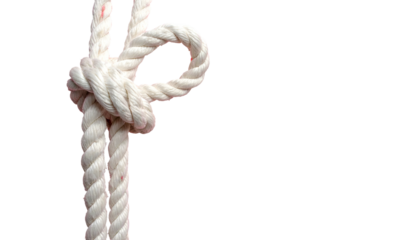 Close-up of a white rope tied in a complex knot, against a solid black background