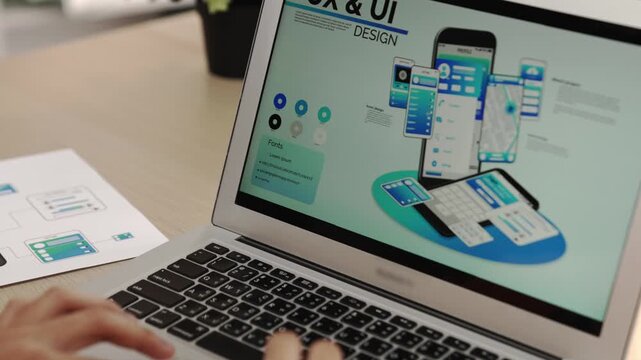 Panorama video of startup UX developer or company employee using laptop design user interface or UI prototype for mobile application or website software with software display on smartphone. Synergic